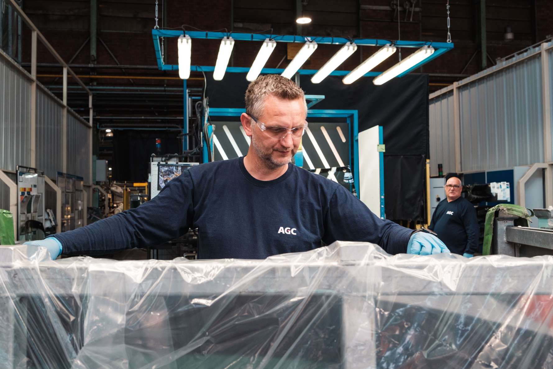 Factory worker holding windshield