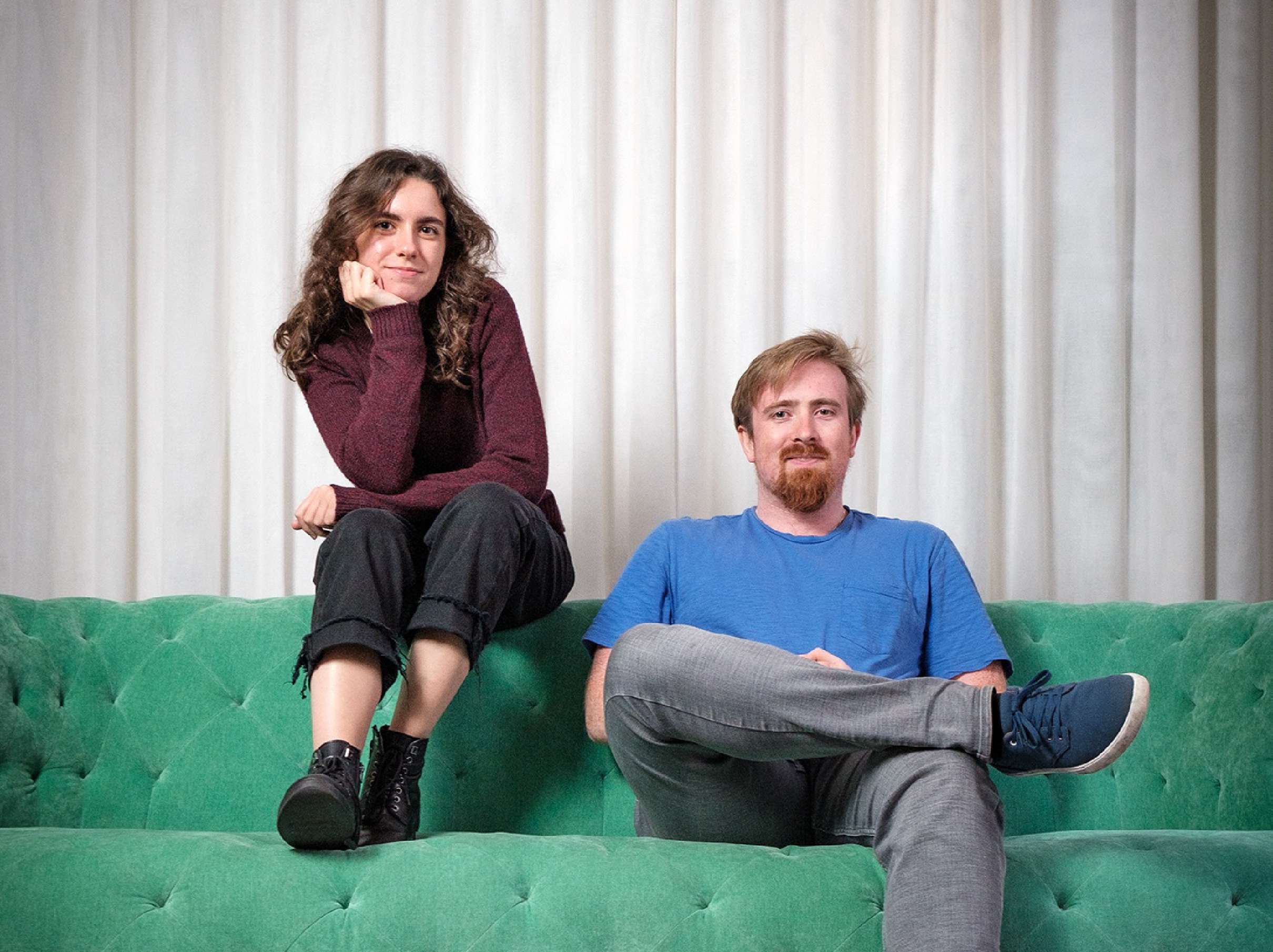 Idil and Connor on a green sofa